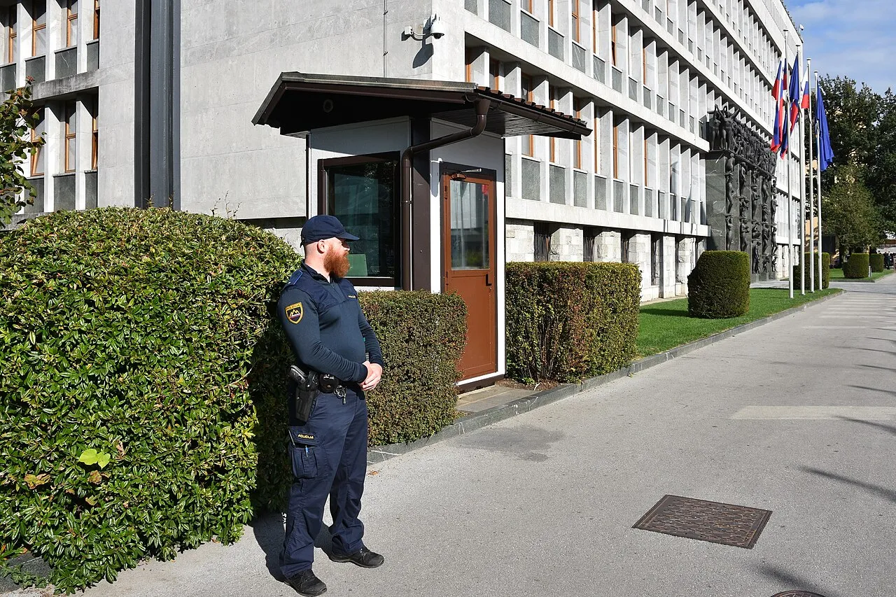 Entreegevel van het Sloveense parlementsgebouw (Državni zbor) in Ljubljana, met het gebeeldhouwde portaal en vlaggen